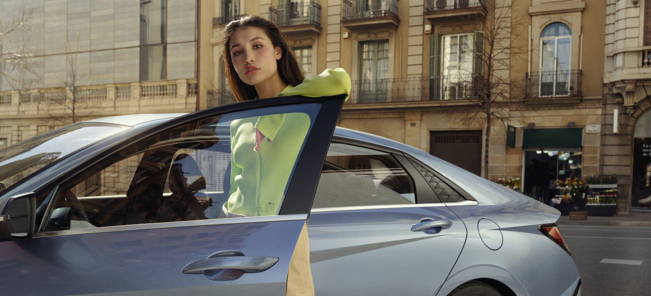 Side-front view of orange Grandi10 with lakeside view at night