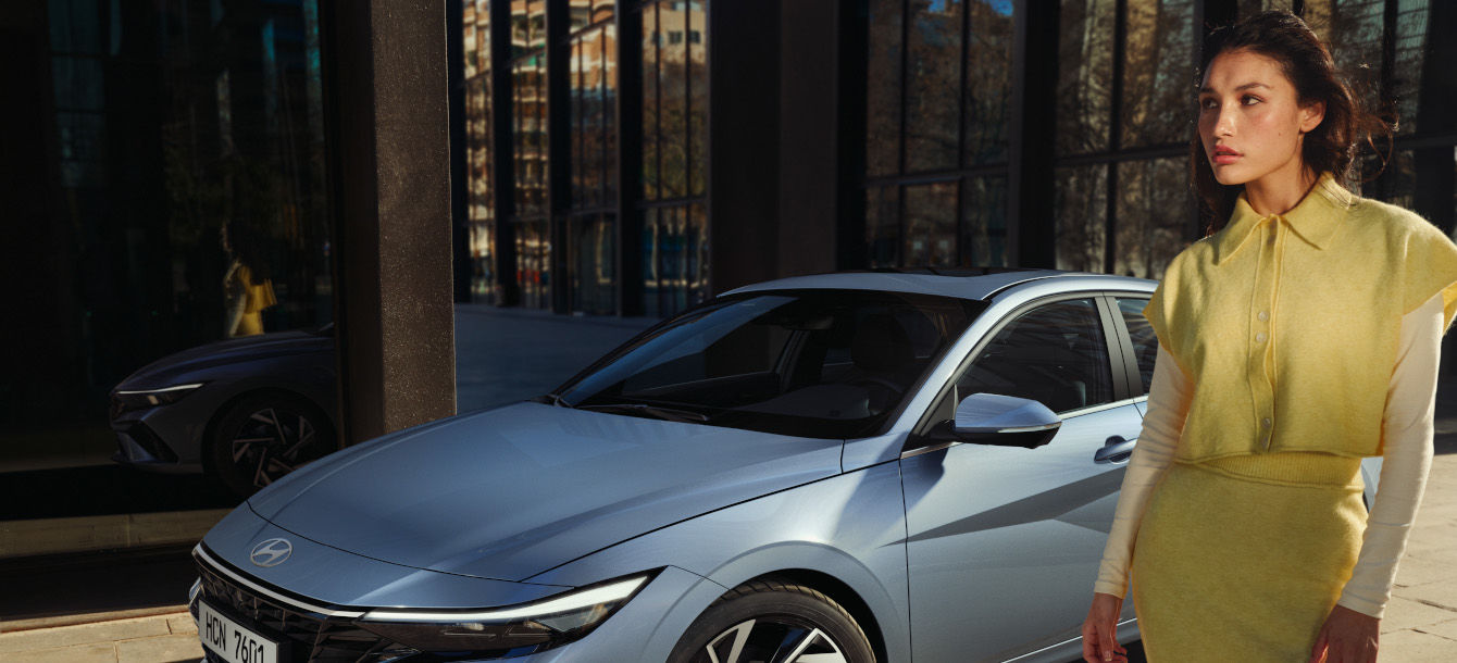 Side-front view of orange Grandi10 with lakeside view at night