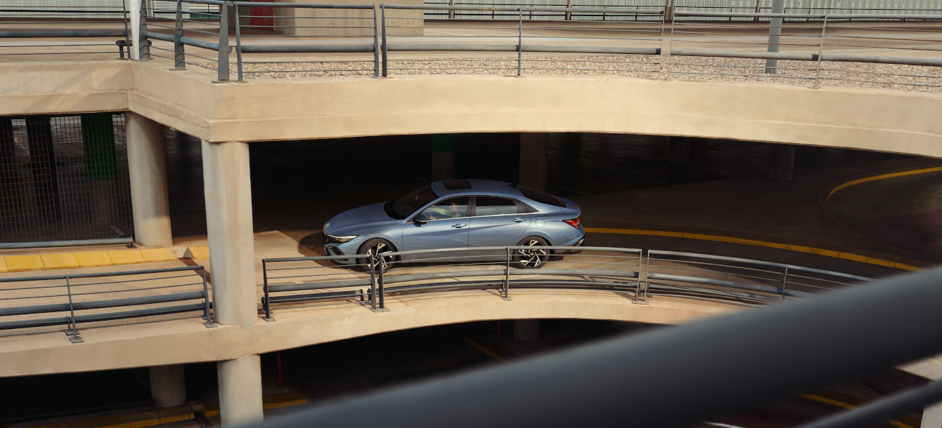 Side-front view of orange Grandi10 with lakeside view at night