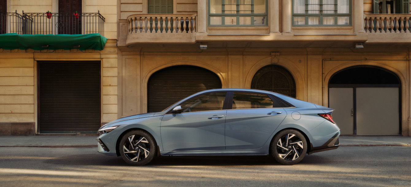 Side-front view of orange Grandi10 with lakeside view at night