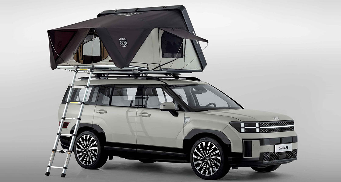 Side-front view of orange Grandi10 with lakeside view at night