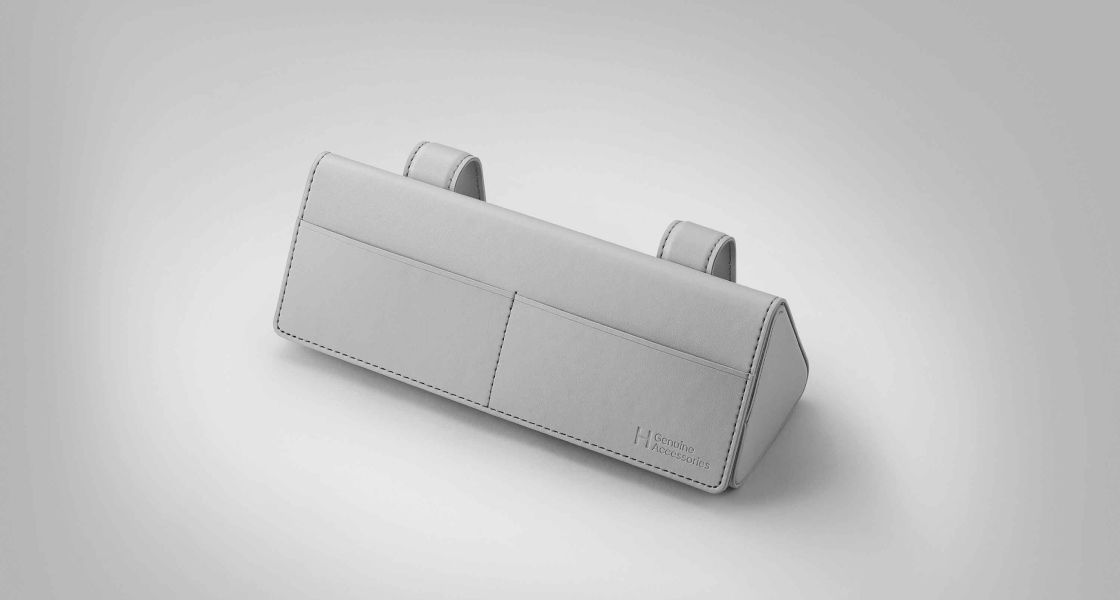 Side-front view of orange Grandi10 with lakeside view at night