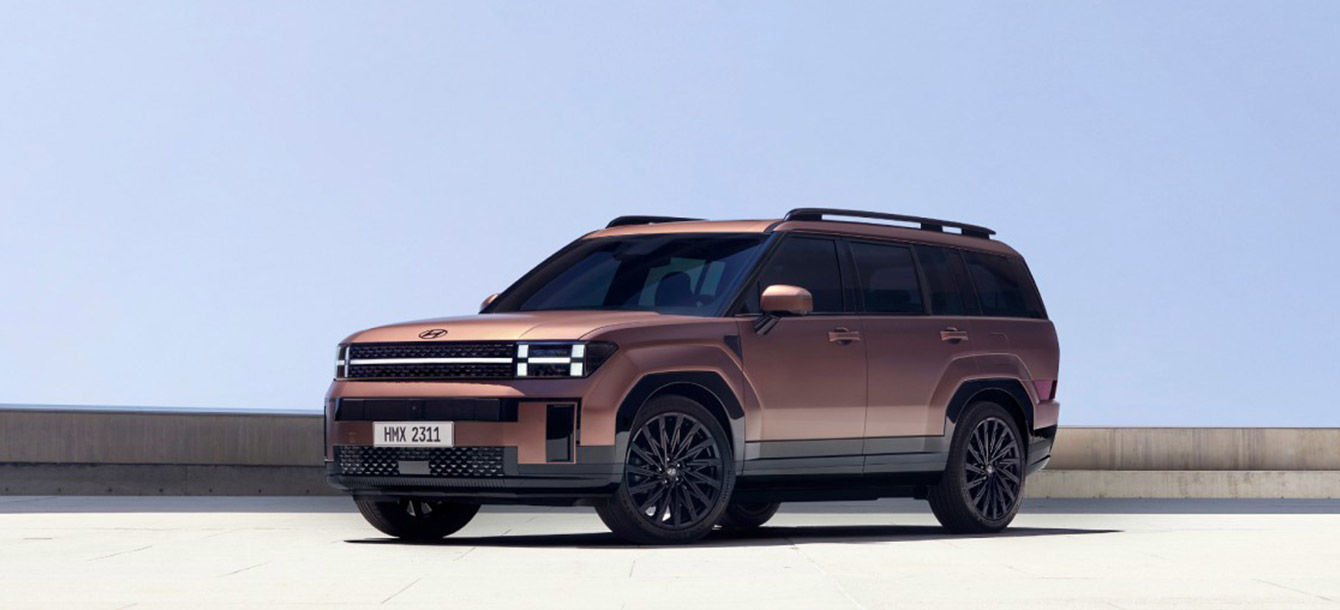 Side-front view of orange Grandi10 with lakeside view at night