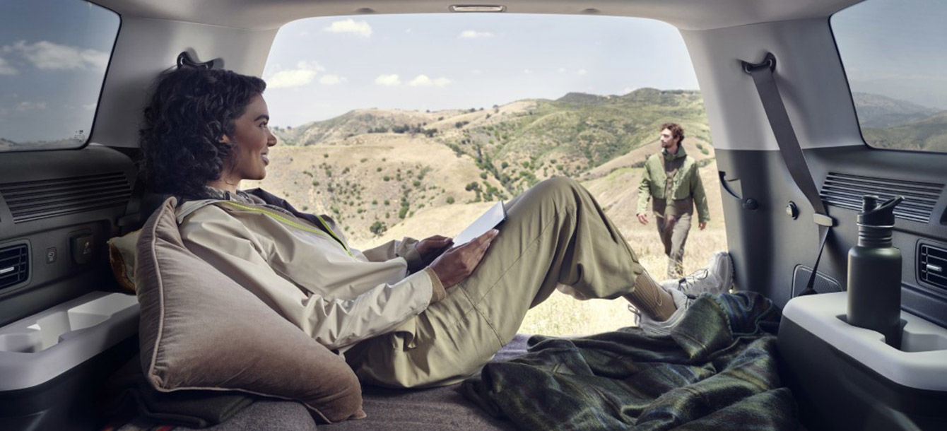 Side-front view of orange Grandi10 with lakeside view at night