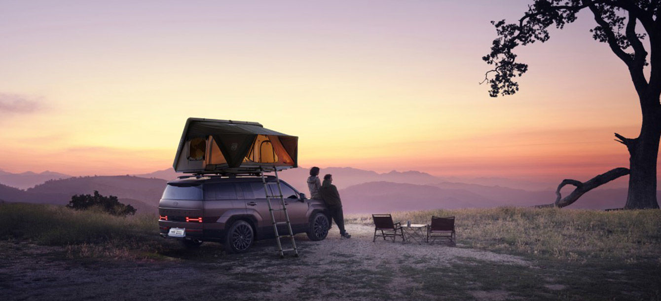 Side-front view of orange Grandi10 with lakeside view at night