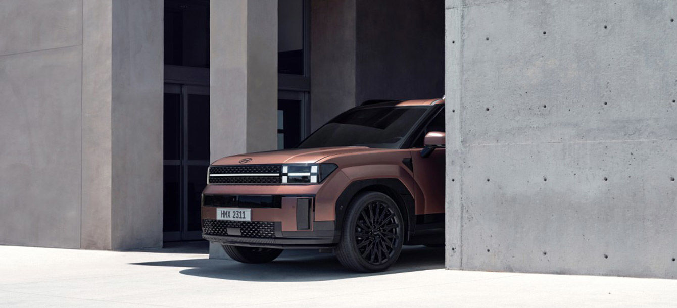 Side-front view of orange Grandi10 with lakeside view at night