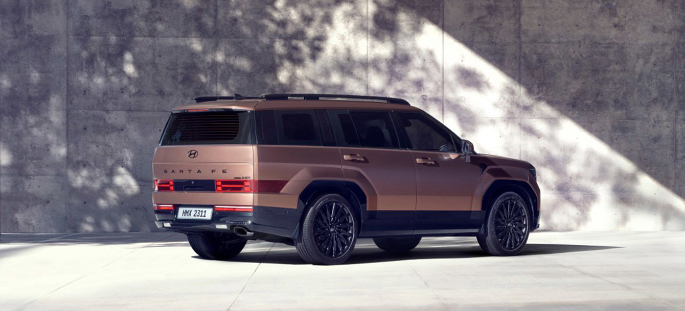 Side-front view of orange Grandi10 with lakeside view at night