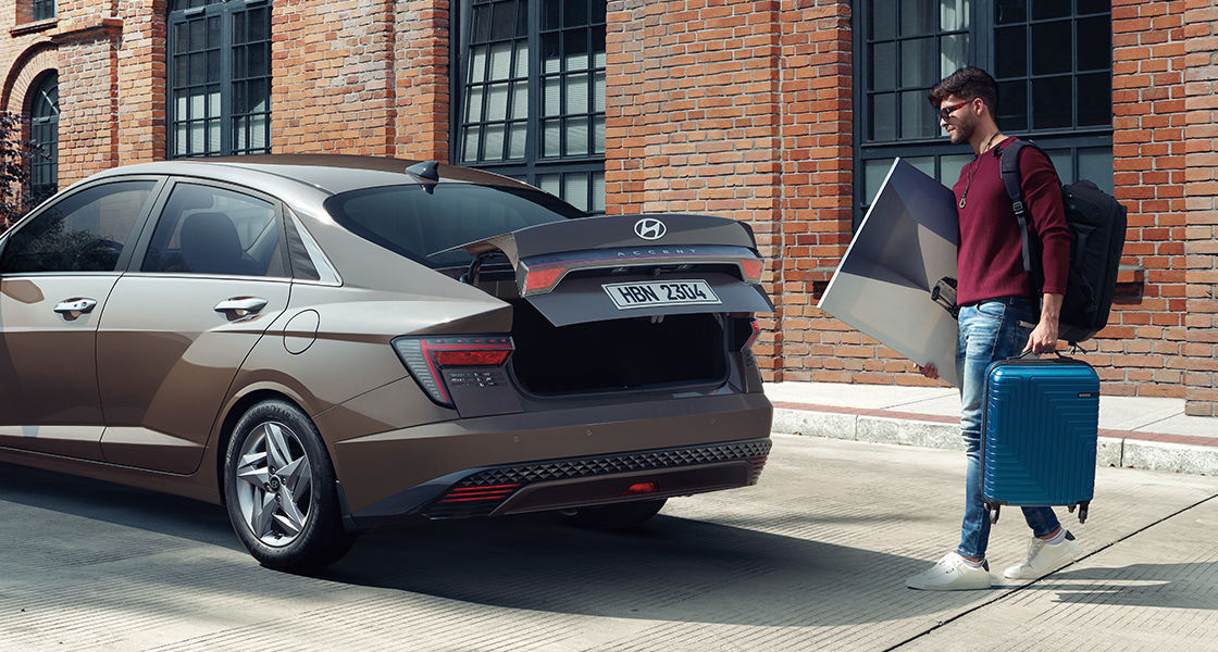 Side-front view of orange Grandi10 with lakeside view at night