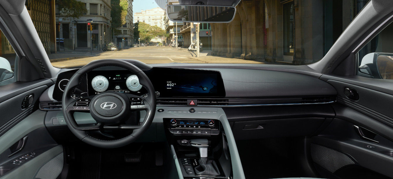 Side-front view of orange Grandi10 with lakeside view at night