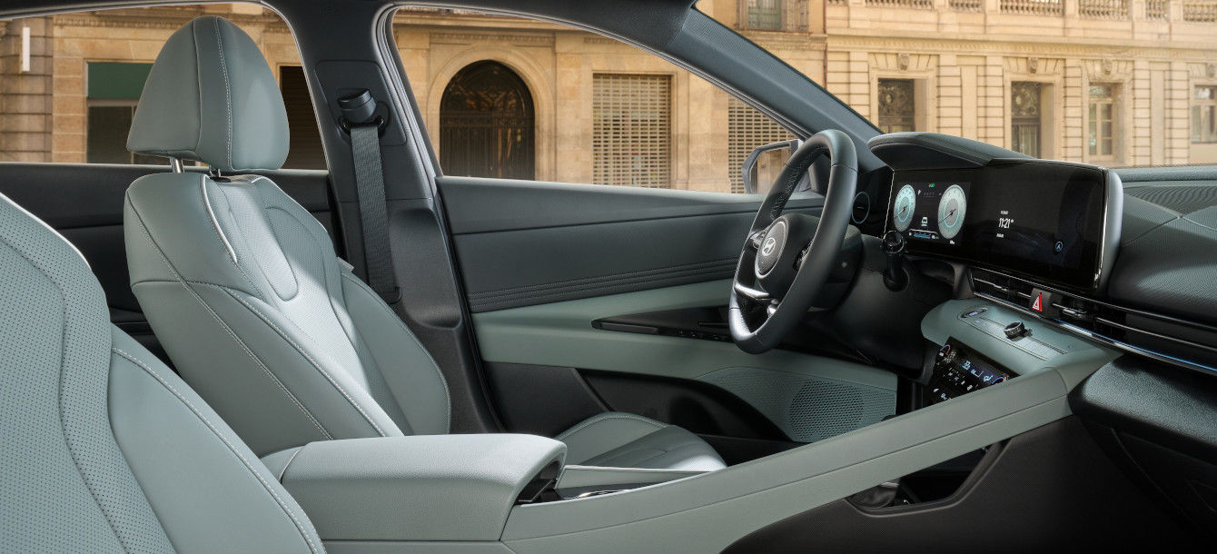 Side-front view of orange Grandi10 with lakeside view at night