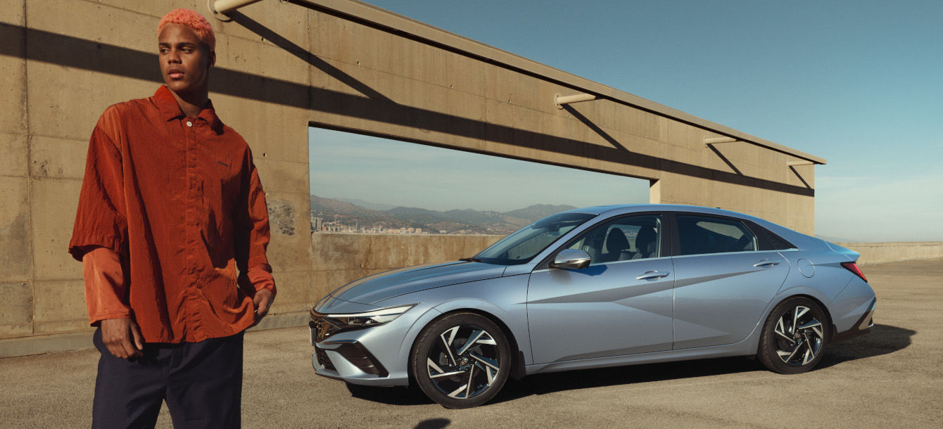 Side-front view of orange Grandi10 with lakeside view at night