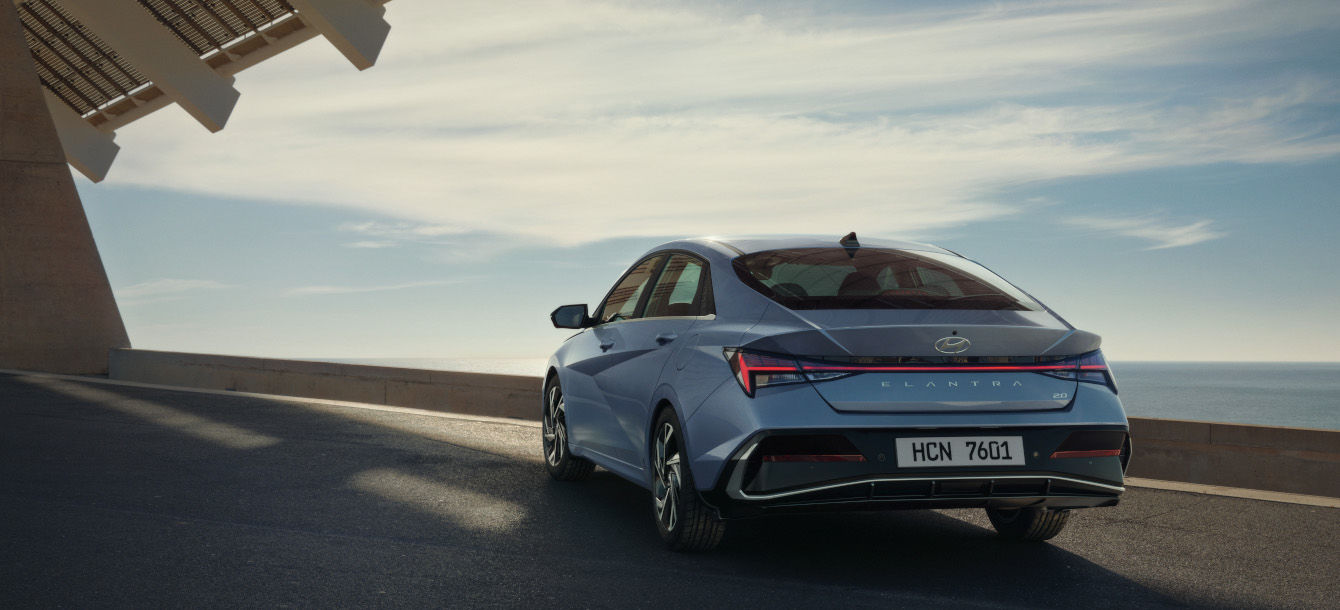 Side-front view of orange Grandi10 with lakeside view at night