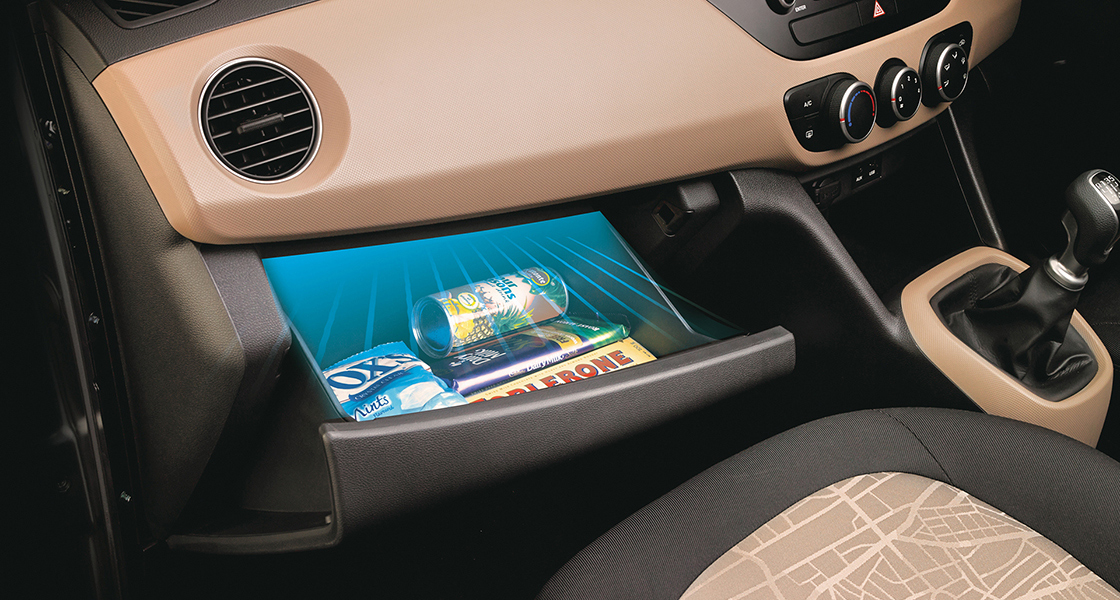 Side-front view of orange Grandi10 with lakeside view at night