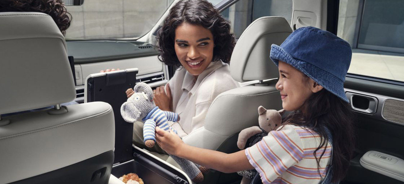 Side-front view of orange Grandi10 with lakeside view at night