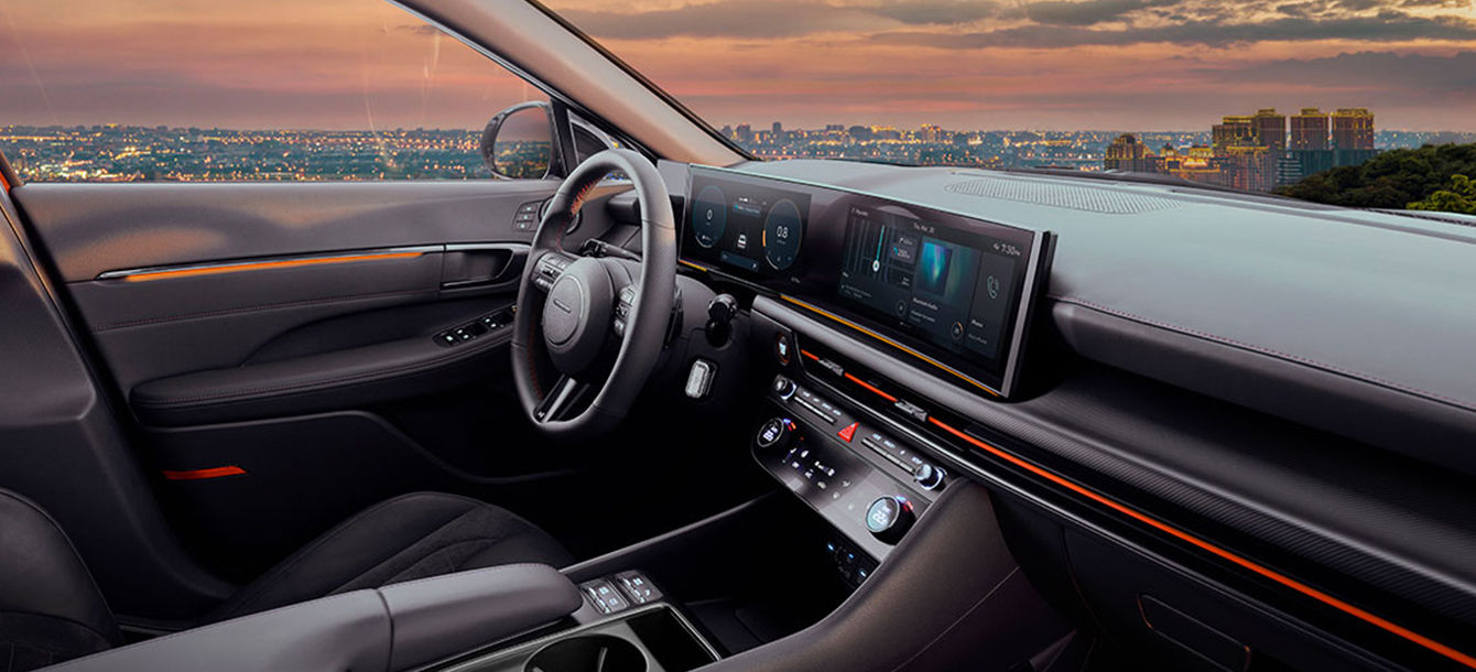 Side-front view of orange Grandi10 with lakeside view at night