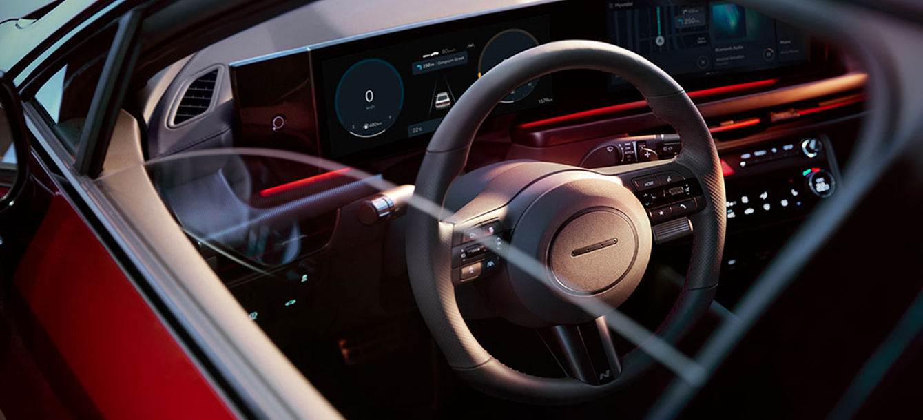 Side-front view of orange Grandi10 with lakeside view at night