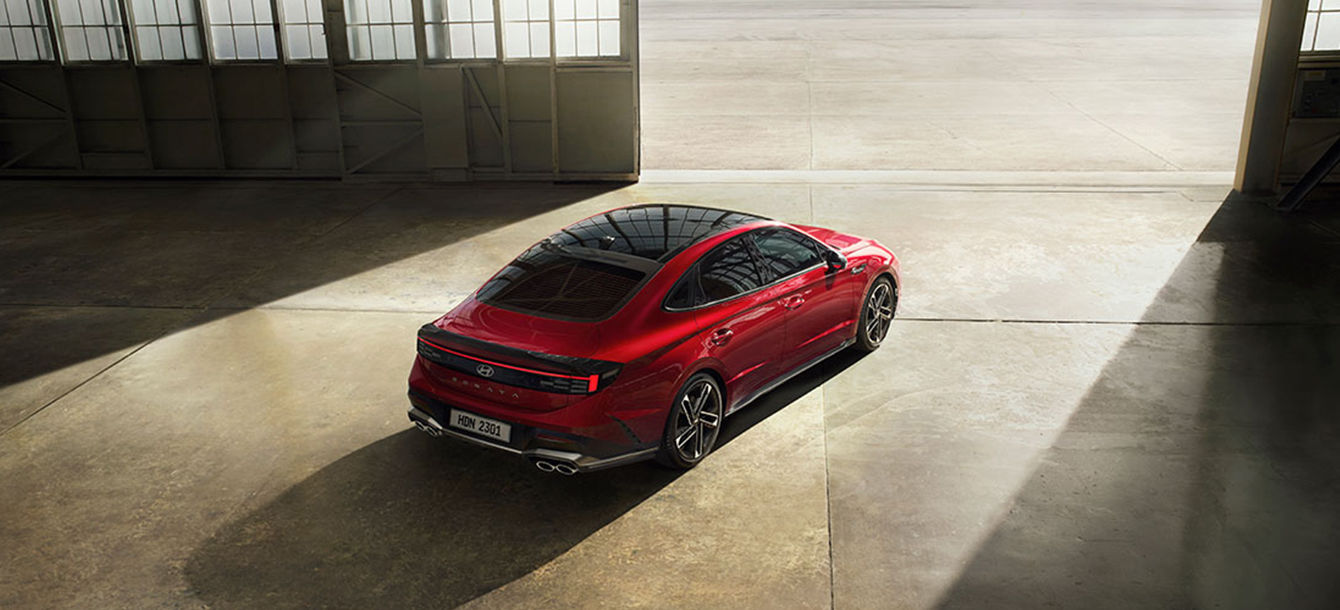 Side-front view of orange Grandi10 with lakeside view at night