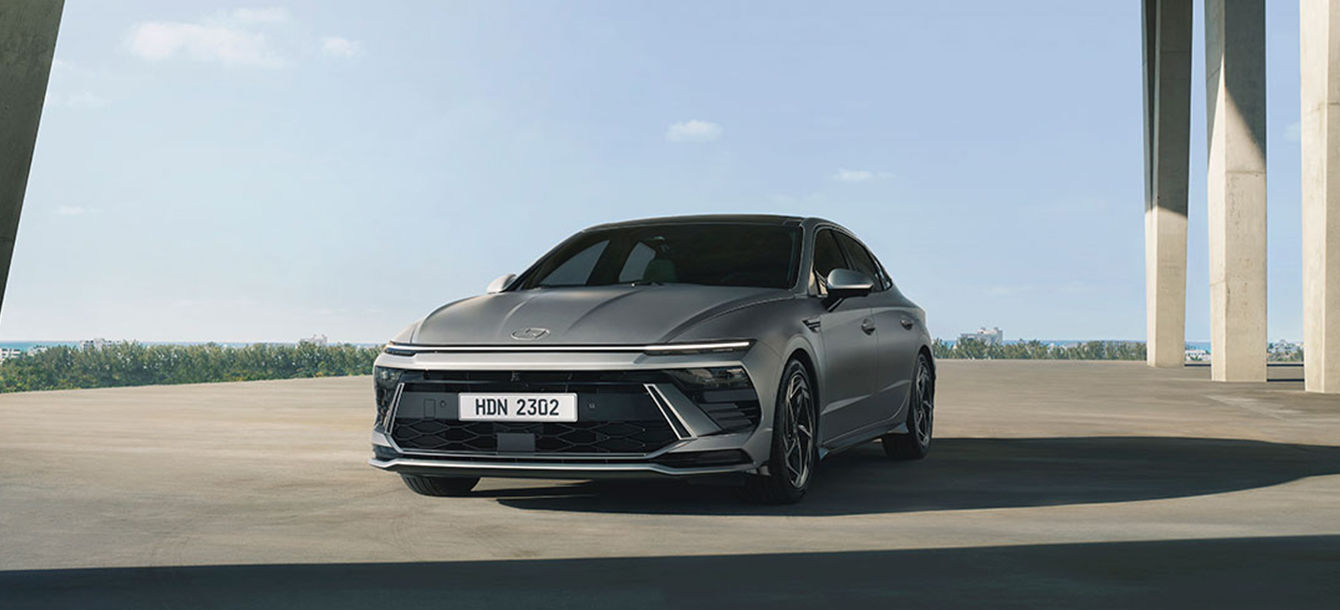 Side-front view of orange Grandi10 with lakeside view at night