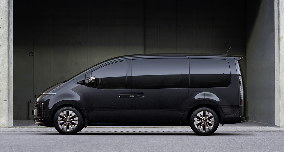 Side-front view of orange Grandi10 with lakeside view at night